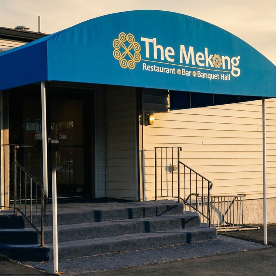 The Mekong Restaurant & Bar Banquet Hall entrance with a blue awning and steps leading to the door.